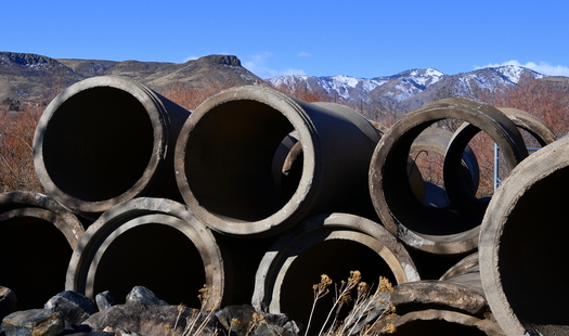 Stacked pipes with a foothills background
