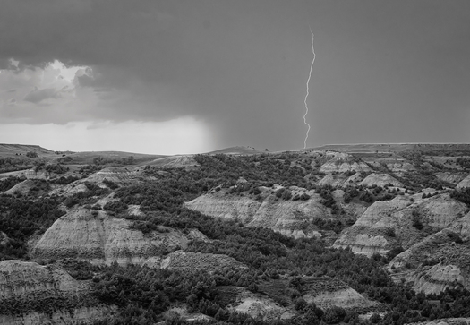 Badlands with a lightning strike in background