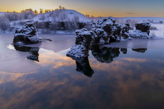 Snowy landscape with reflected pink clouds