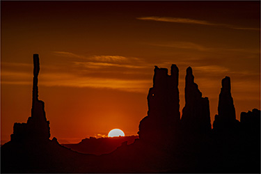 Vertical rocks framing a rising sun