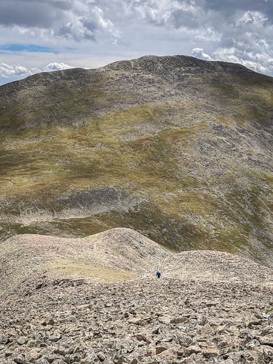 Hiker dwarfed by mountain scenery